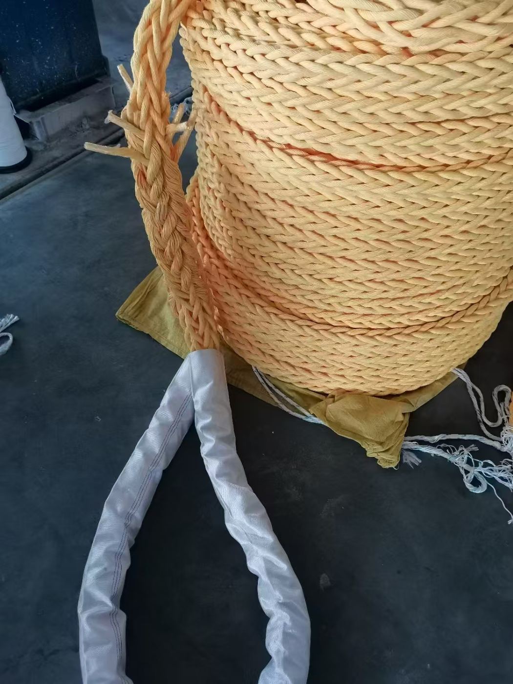 Coil of 12-strand mooring line with a spliced eye in a protective sleeve
