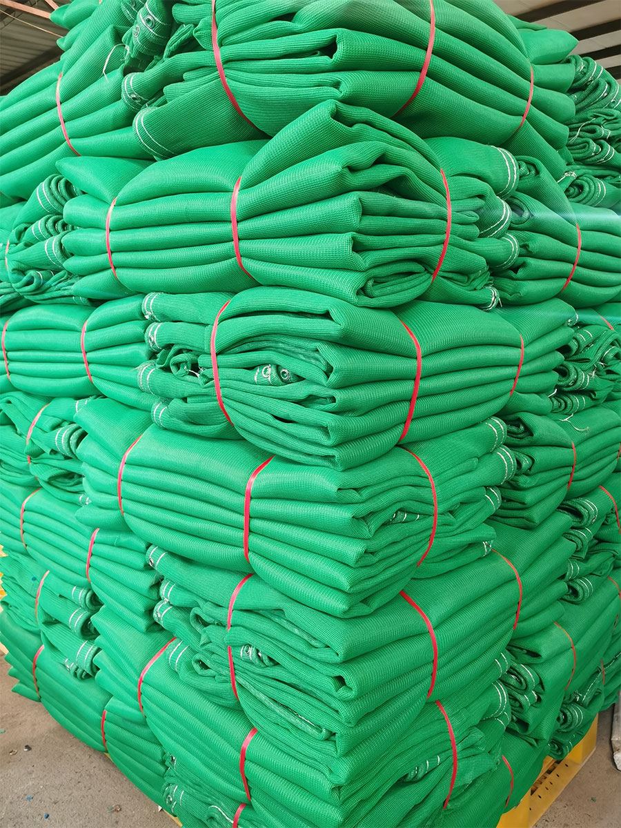 Green safety nets folded and strapped with red bands on a pallet